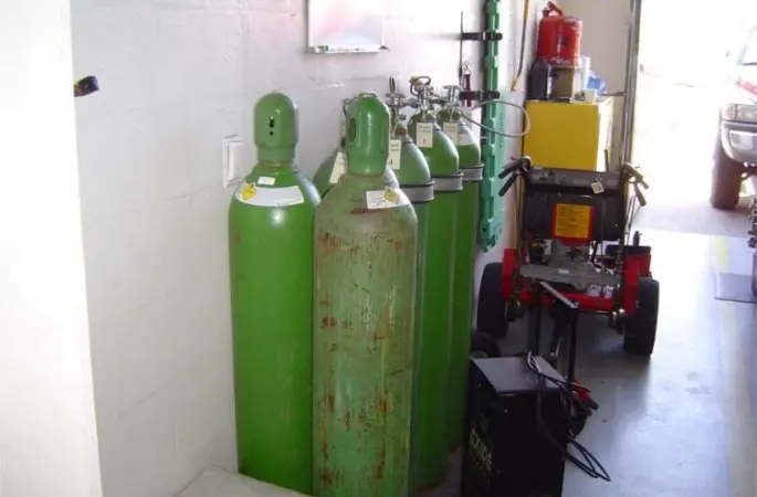 Green gas cylinders and equipment in garage.